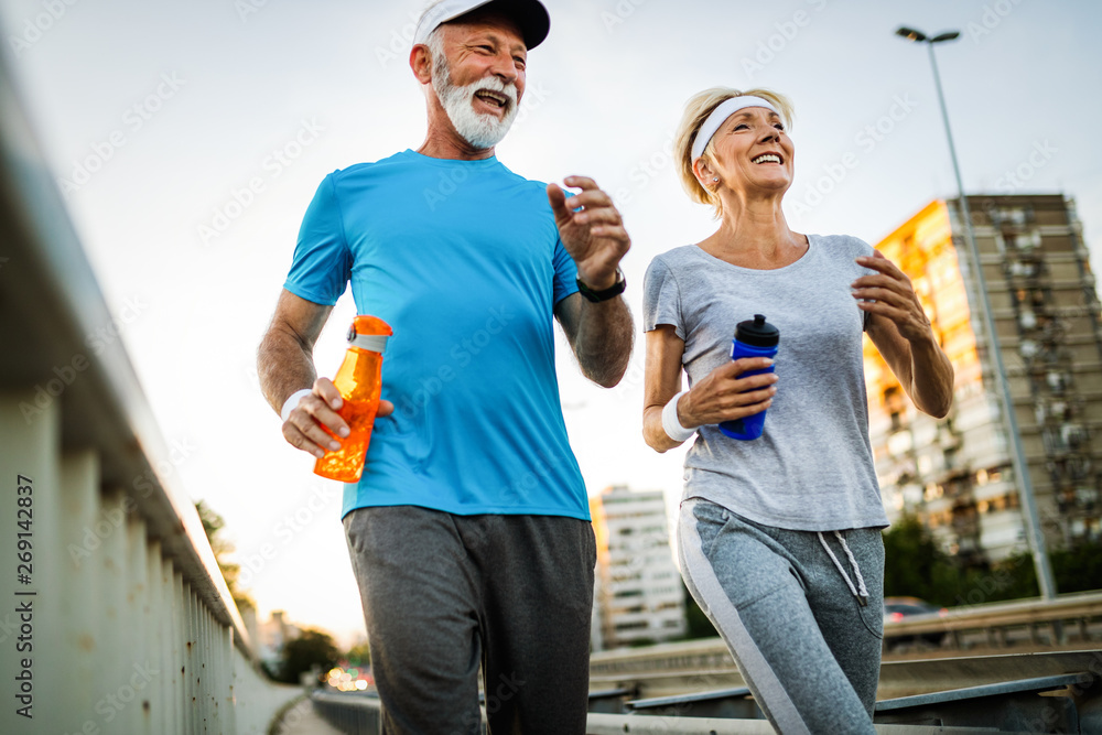 Fitness, sport, people, exercising and lifestyle concept - senior couple running - obrazy, fototapety, plakaty 