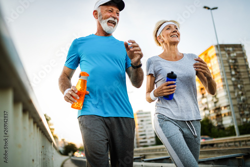 Fitness, sport, people, exercising and lifestyle concept - senior couple running
