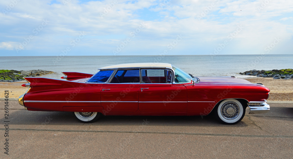 Fotografiet, Poster Classic Red 1950's 4 door Cadillac motor car parked on  seafront promenade på Europosters.se