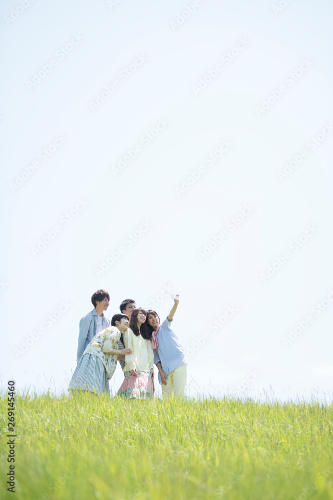 草原で自分撮りをする大学生