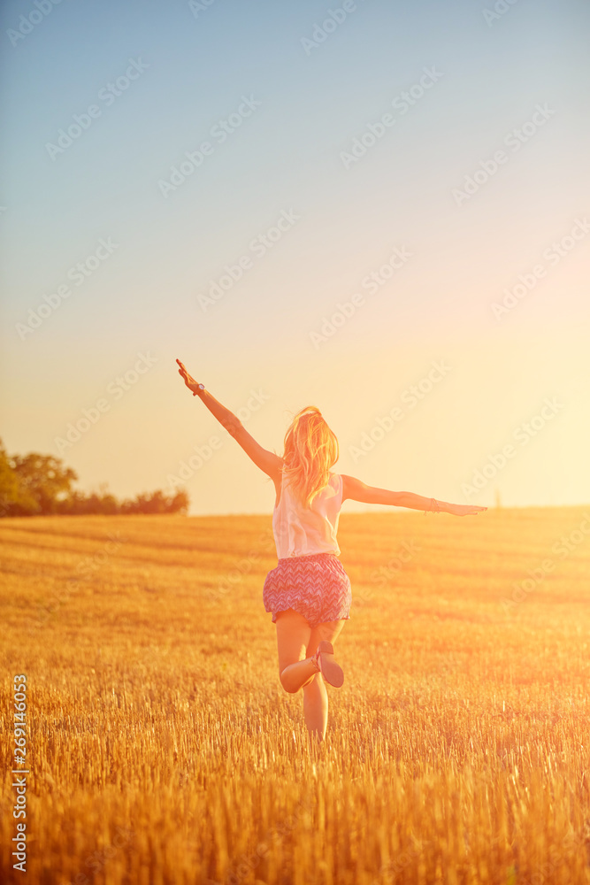 Young woman jumping and running in a wheat field. Young woman jumping and running in a wheat field.
