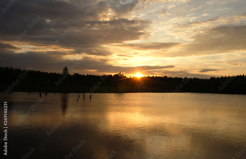 Obraz premium Bright sunset on a forest lake. Silence in the evening.