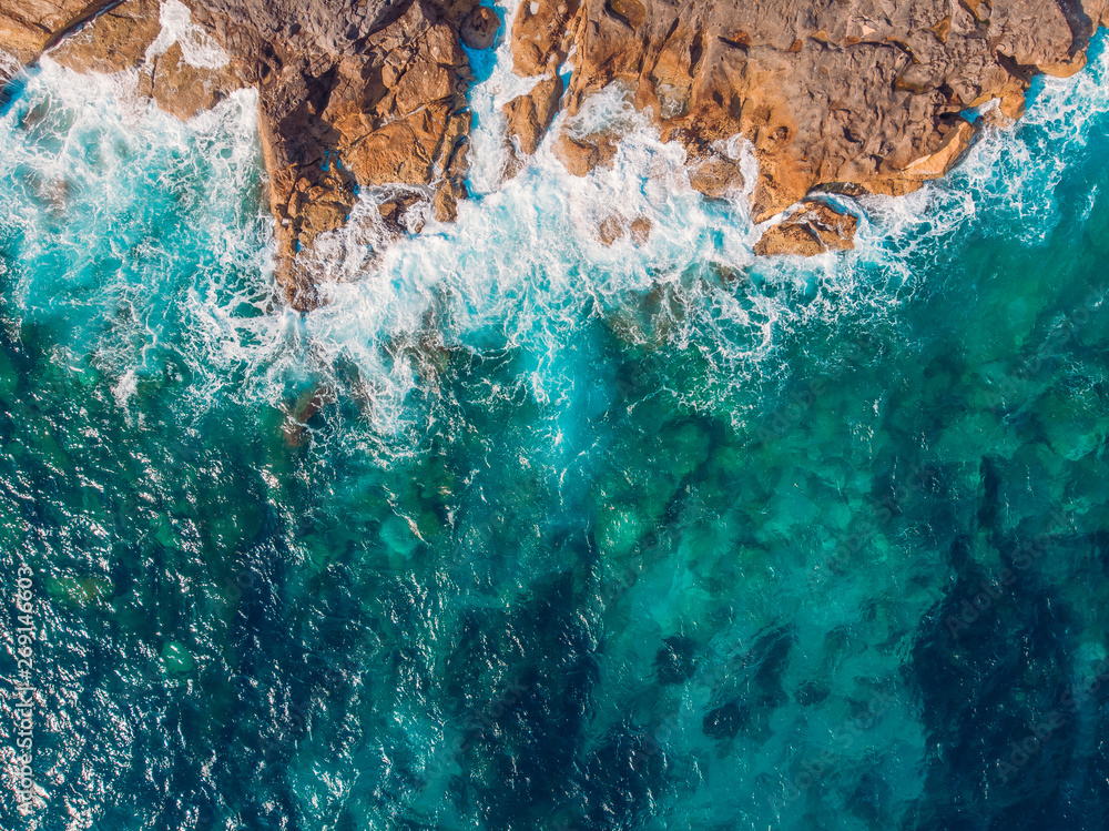 Azure clear water hits the rocky coast of coral beach. Aerial top view Azure clear water hits the rocky coast of coral beach. Aerial top view