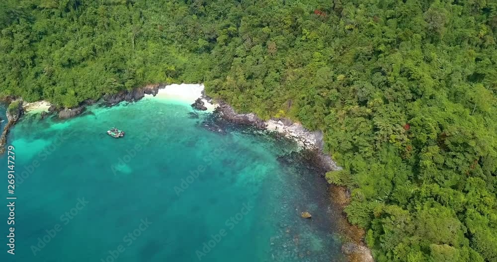 uninhabited island covered with lots of trees of forest and white sand on its beach with a parked ship near, Myanmar, Asia uninhabited island covered with lots of trees of forest and white sand on its beach with a parked ship near, Myanmar, Asia