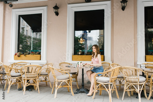 beautiful girl sitting at a table in a cafe. The concept of loneliness and self-sufficiency