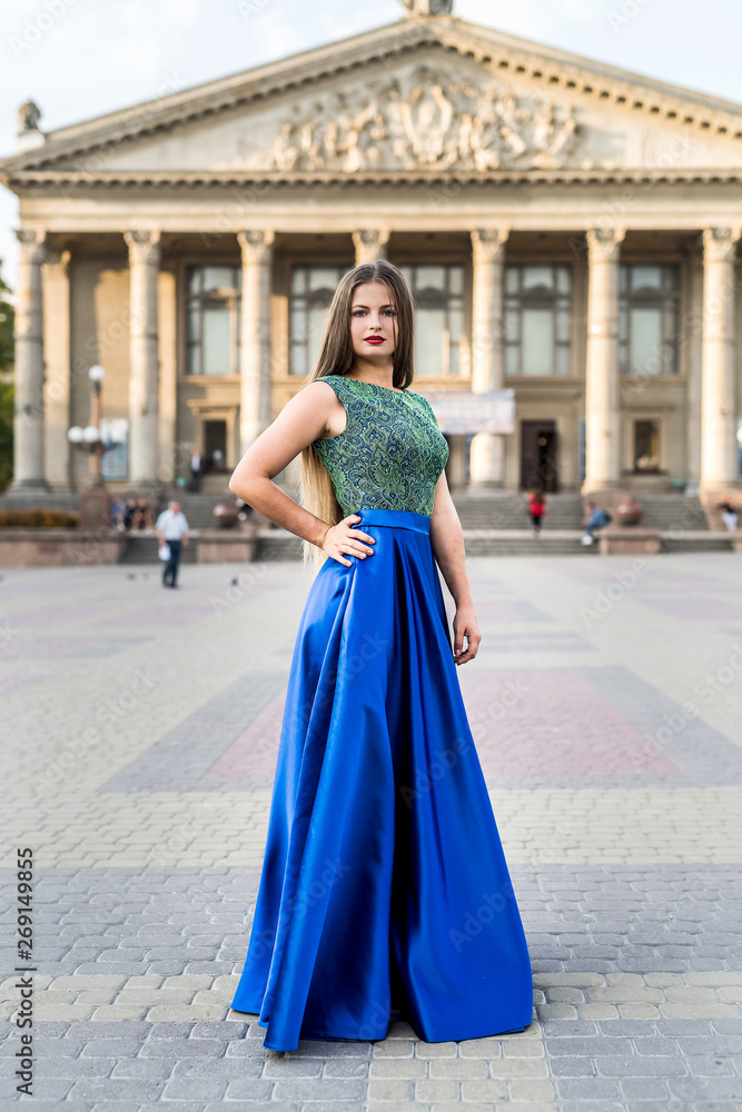 Beautiful brunette woman wearing red dress posing on the street Beautiful brunette woman wearing red dress posing on the street