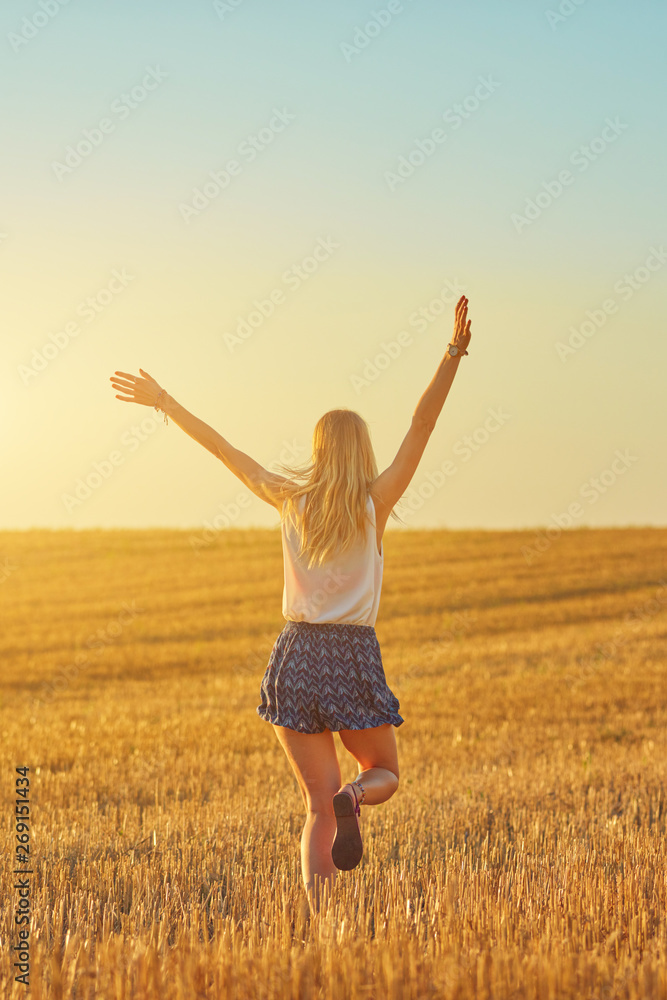 Cute young woman jumping in a wheat field. Cute young woman jumping in a wheat field.