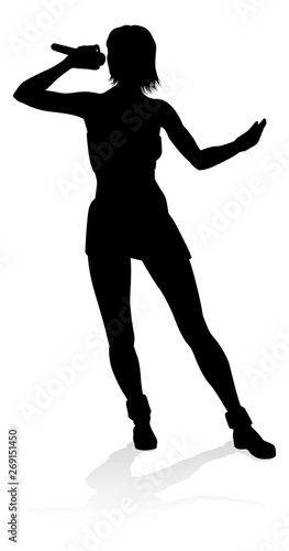 A woman singer pop, country music, rock star or even hiphop rapper artist vocalist singing in silhouette