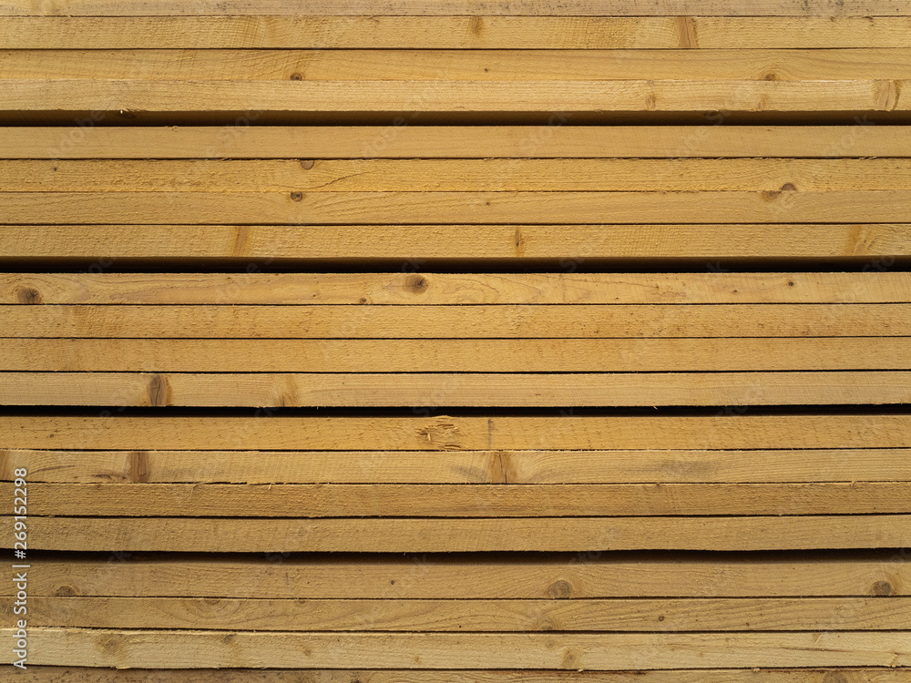 Obraz premium Lots of planks stacked on top of each other in the warehouse. Lumber for further use in construction