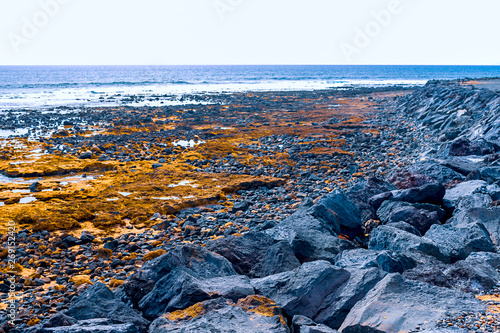 View of the Atlantic coast in Tenerife. Beach, volcanic stones, pebbles.
