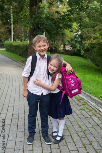 Happy children go back to school. Little school children hugging. Beginning of lessons. First day of fall. September 1 and back to school concept. © polya_olya