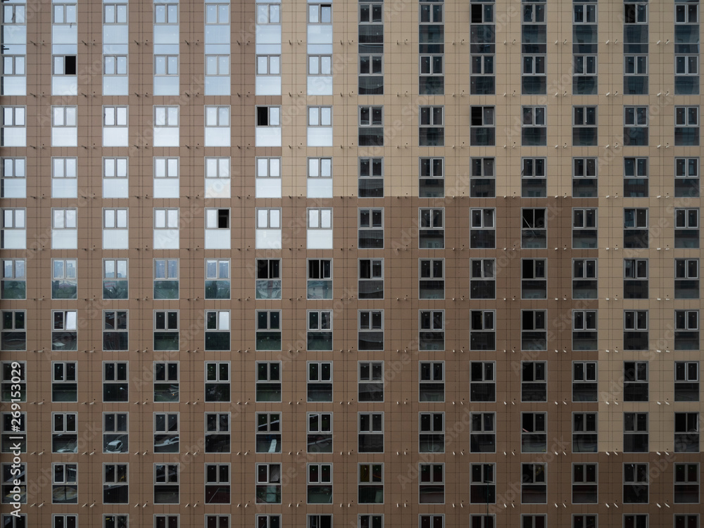 High multi-storey building with lots of Windows. Perfectly flat Windows on the plane of the skyscraper