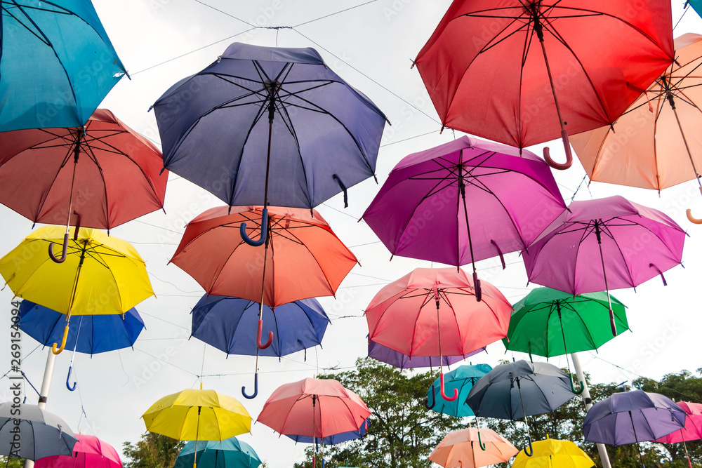 Obraz premium Colorful umbrellas hanging on the rope.