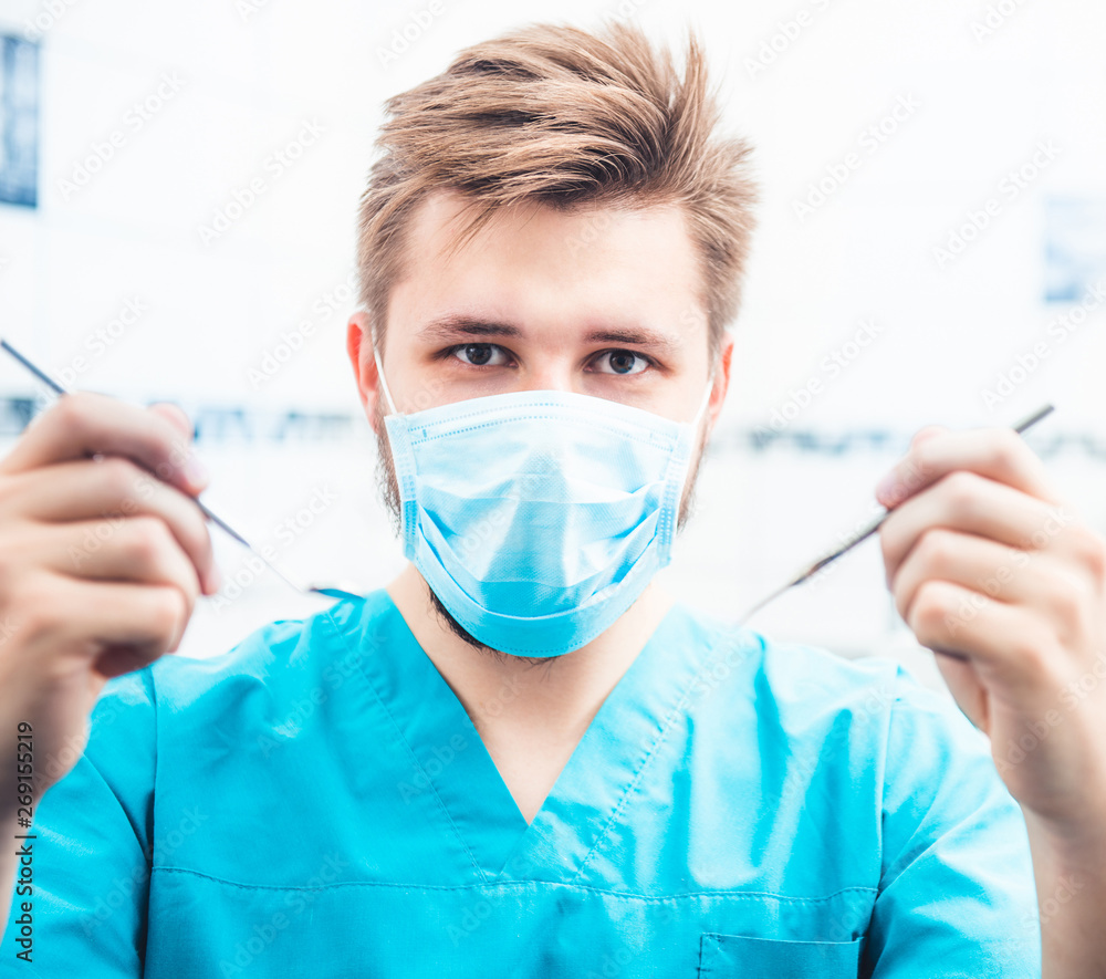 Dentist with mask and uniform holding tools Dentist with mask and uniform holding tools