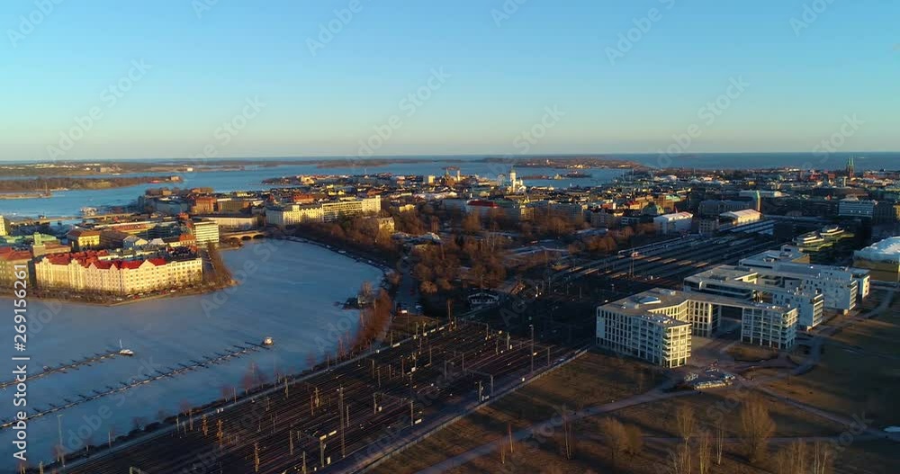 Aerial, tracking, drone shot, of Helsinki at sunset, the railway station, Kaisaniemi park and the cityscape in Helsingfors, above toolonlahti, at golden hour, on a sunny spring evening, in Finland Aerial, tracking, drone shot, of Helsinki at sunset, the railway station, Kaisaniemi park and the cityscape in Helsingfors, above toolonlahti, at golden hour, on a sunny spring evening, in Finland