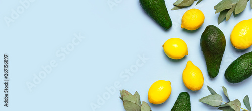 Ripe fresh avocado, fresh citrus lemons, eucalyptus twigs on pastel blue background top view Flat lay copy space. Fruits Healthy food concept, diet, healthy lifestyle. Creative food background