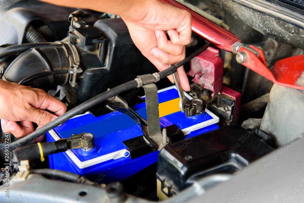 The man turn wrench for Change New Battery of old car The man turn wrench for Change New Battery of old car