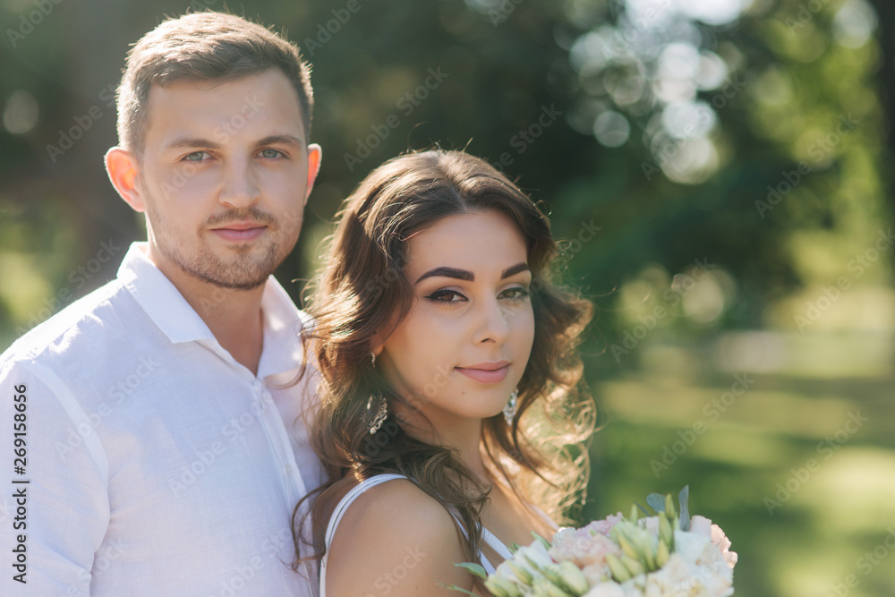 Portrait of beautiful couple in white clothes. Handsome man and elegant lady. Brilliant smile Portrait of beautiful couple in white clothes. Handsome man and elegant lady. Brilliant smile