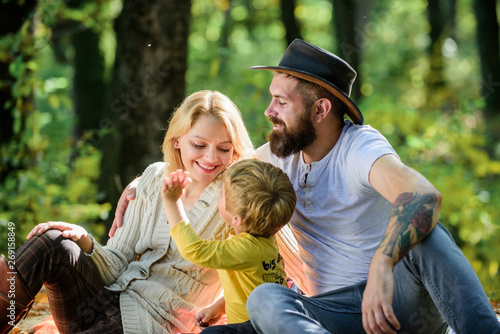 Good day for spring picnic in nature. Explore nature together. Family day concept. Mom dad and kid boy relaxing while hiking in forest. Family picnic. Mother father and little son sit forest picnic © be free