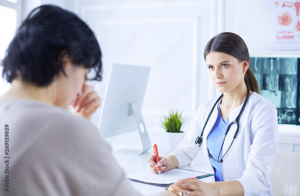 Female doctor calming down a patient at a hospital consulting room, holding her hand Female doctor calming down a patient at a hospital consulting room, holding her hand