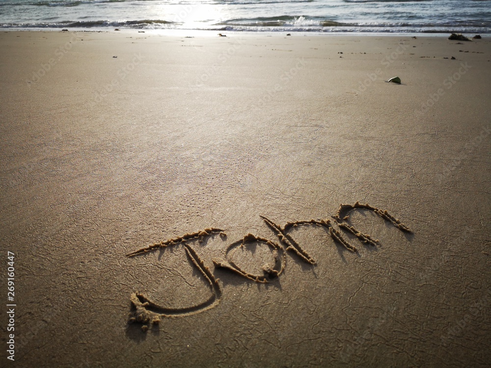 Obraz premium An English name John written on the beach.