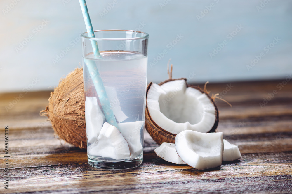 Coconut water in the composition with white flesh on wooden background. Organic product widely used in cosmetology Coconut water in the composition with white flesh on wooden background. Organic product widely used in cosmetology