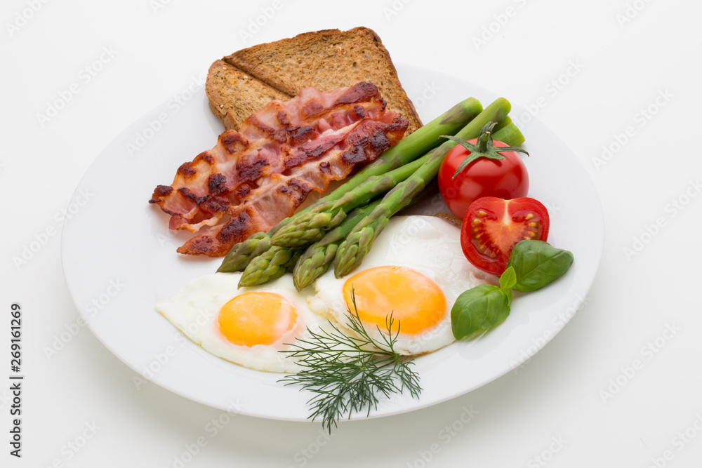 Fried eggs with bacon on the wooden table.