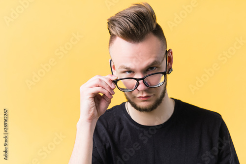 Quadro su tela Portrait of sceptic millennial guy on yellow background