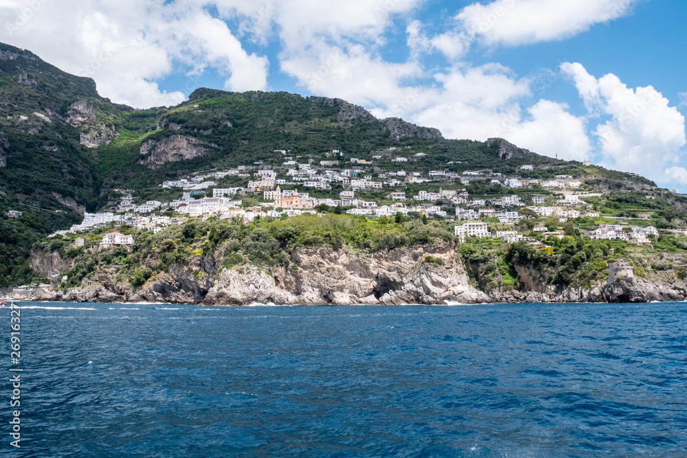 Positano, Salerno, Campania, Italy, Europe - may 19 2019: view of Praiano from the sea on a boat leaving the port on Amalfi Coast. Wake of a ship with a marine village in the background