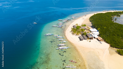 Starfish Island, Puerto Princesa, Palawan. Lots of boats on the beach, tourist route. Island hopping Tour at Honda Bay, Palawan. An island of white sand with mangroves.