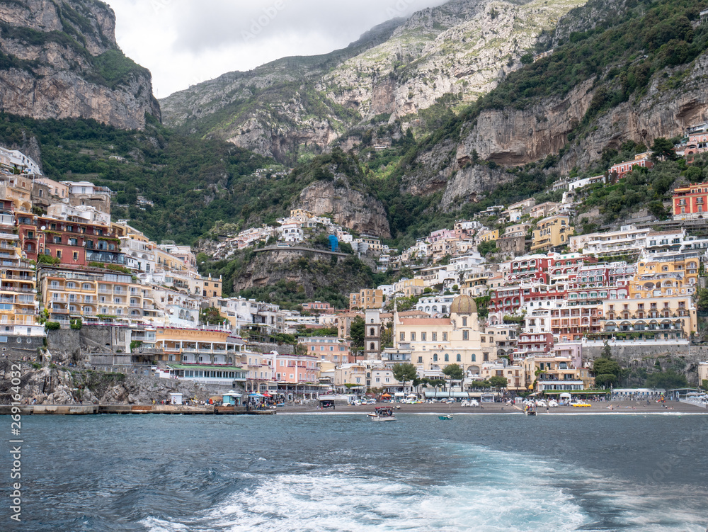 Positano, Salerno, Campania, Italy, Europe - may 19 2019: view of Positano from the sea on a boat leaving the port on Amalfi Coast. Wake of a ship with a marine village in the background