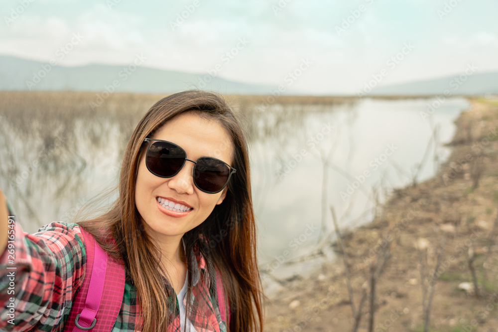 Traveler woman taking selfie at the lake in summer time. Traveler woman taking selfie at the lake in summer time.