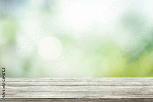 Green blurred background with wooden table