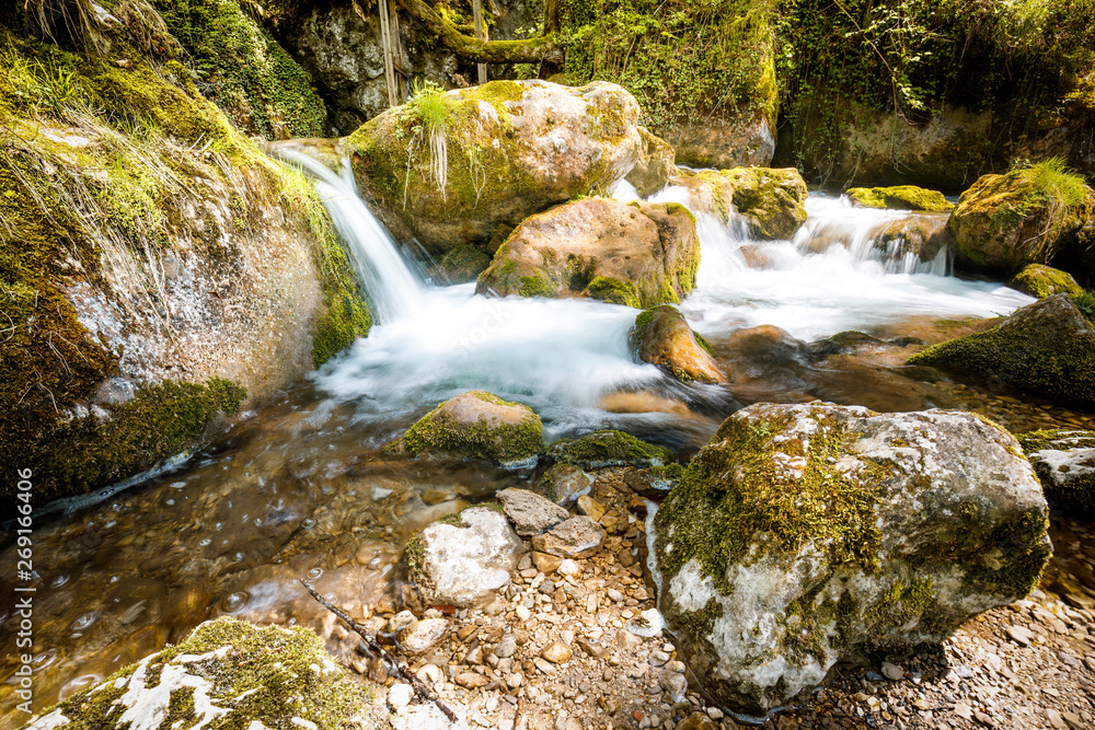 Cascade falls over mossy rocks - myrafalls during spring