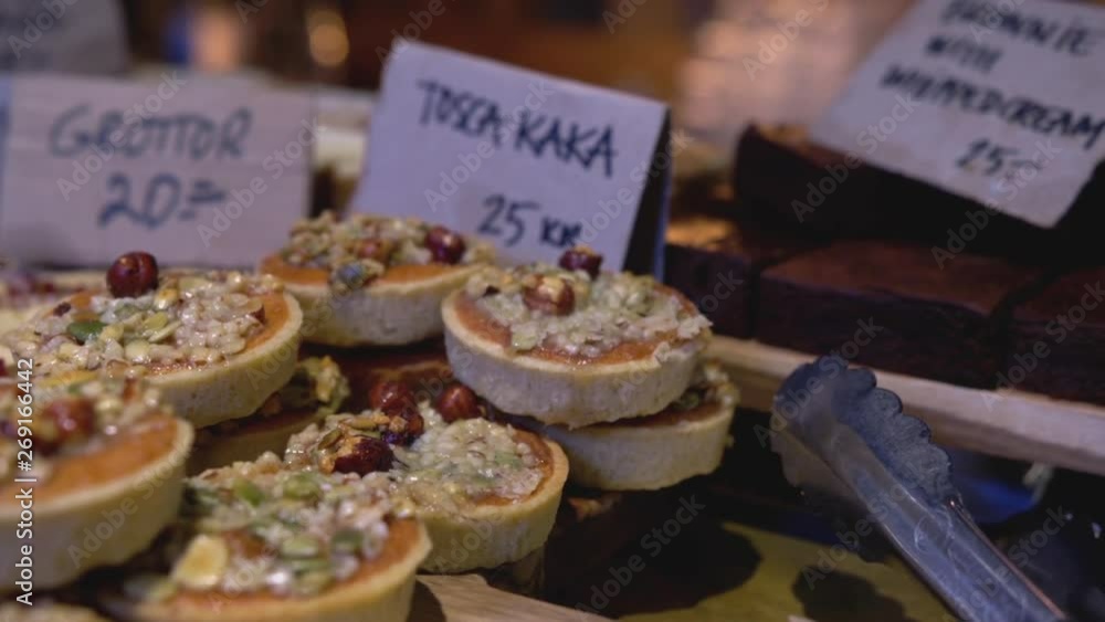 Slow pan right over a spread of Swedish Fika pastries, with small handwritten signs in the background Slow pan right over a spread of Swedish Fika pastries, with small handwritten signs in the background