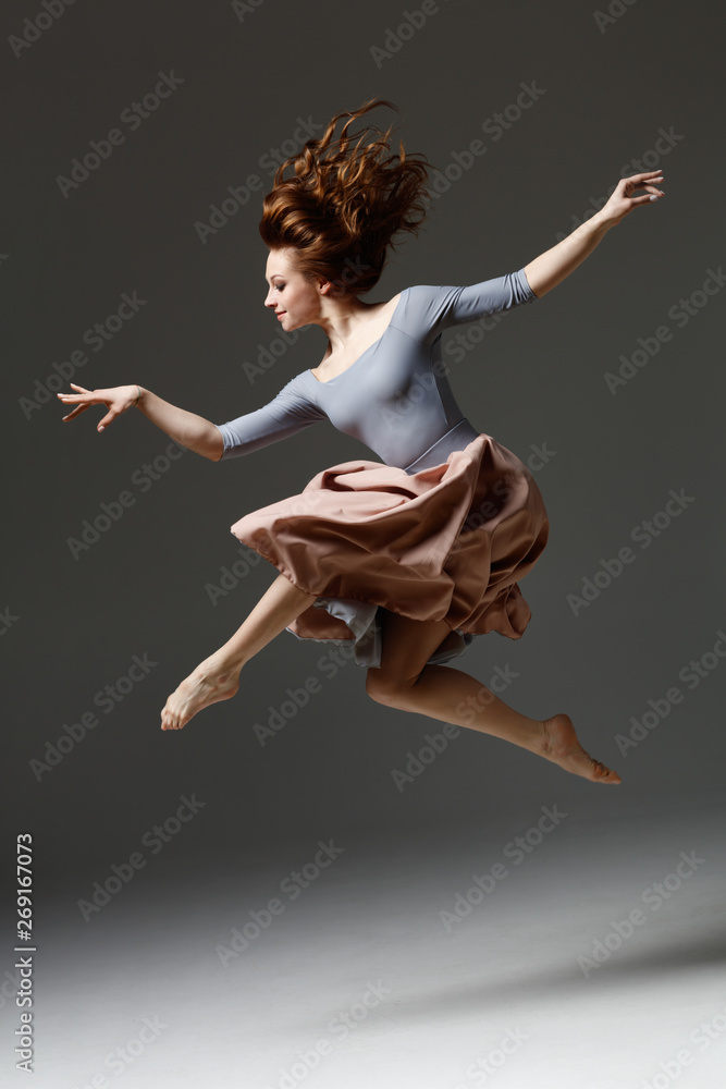 the modern dancer jumping on a gray background