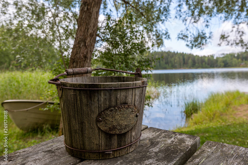 An old wooden bucket and the lake on the background, Finland