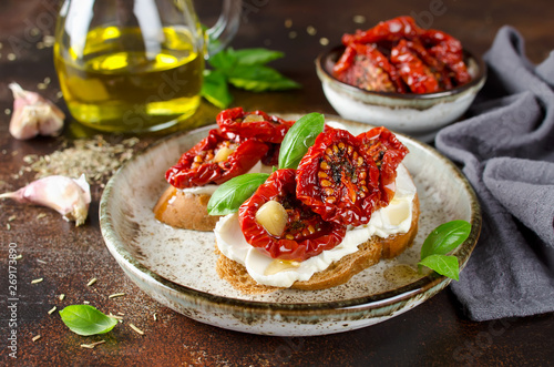 Bruschetta with olive oil, sundried tomatoes, cottage cheese and fresh basil photo