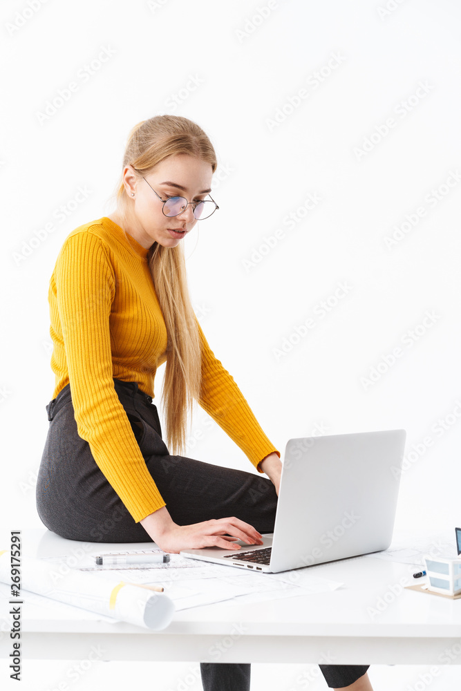 Beautiful young woman sitting on the desk, working Beautiful young woman sitting on the desk, working