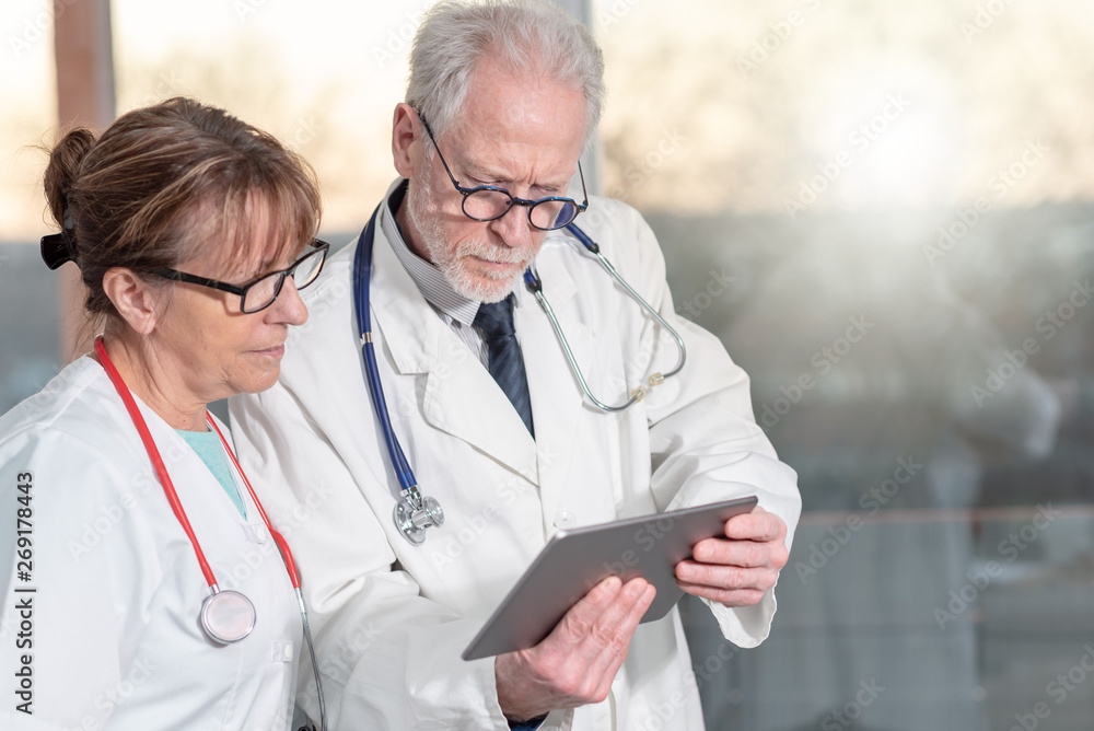 Fototapeta premium Two doctors discussing about medical report on tablet