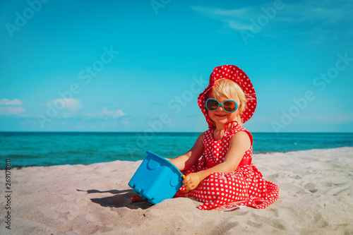 cute little girl play with sand on beach