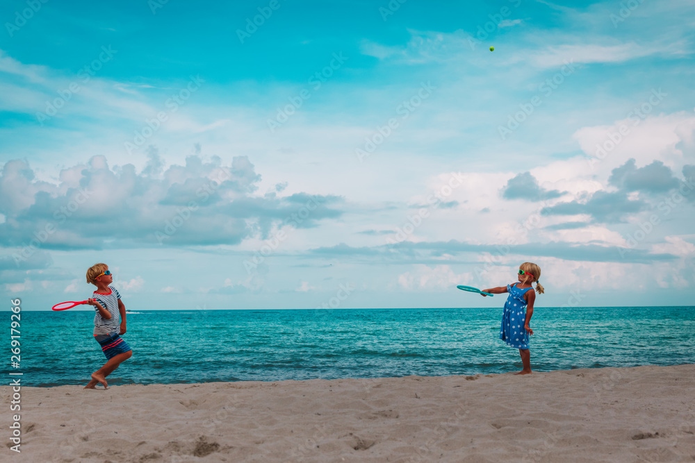 kids- boy and girl- play tennis on beach kids- boy and girl- play tennis on beach