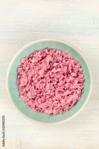 A bowl of pink Himalayan sea salt, shot from above with a place for text