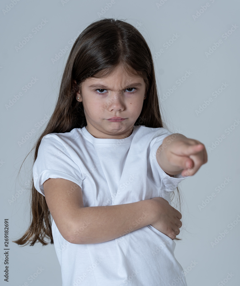 Pretty little girl with a angry facial expression pointing and looking mad at the camera. Pretty little girl with a angry facial expression pointing and looking mad at the camera.
