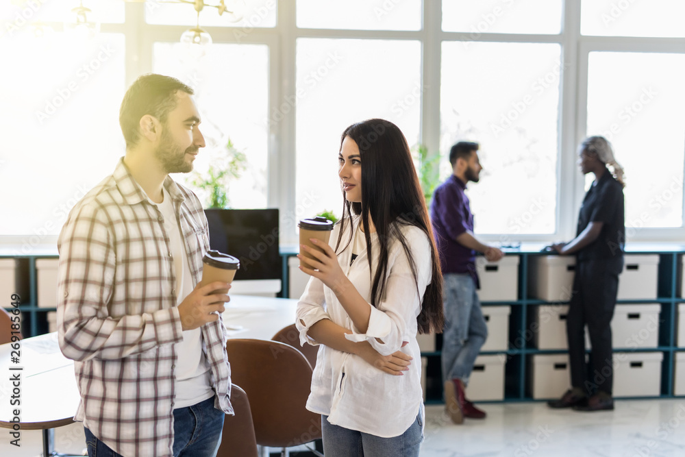 Fototapeta premium Casual coworkers drinking coffee in front of the office