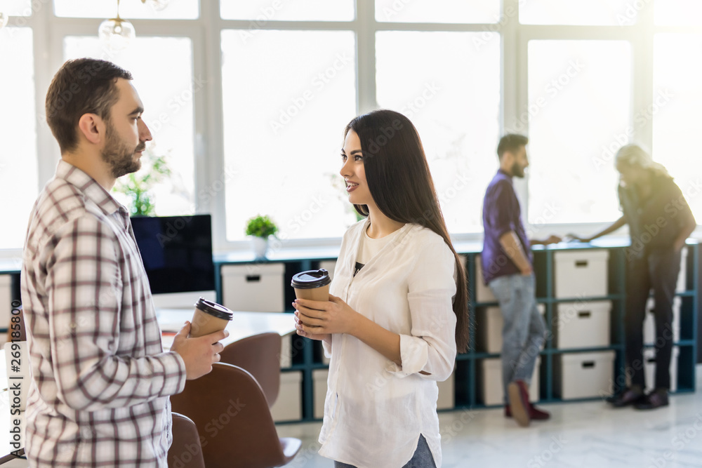Casual coworkers drinking coffee in front of the office Casual coworkers drinking coffee in front of the office