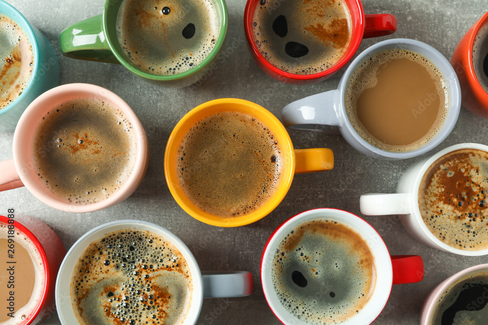 Multicolored cups of coffee on grey table as background, top view Multicolored cups of coffee on grey table as background, top view