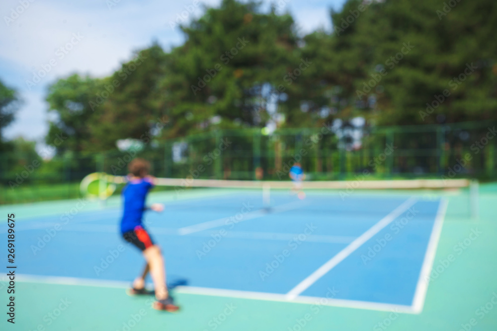 Obraz premium Teenager boy playing tennis on court. Sport summer concept. Blurred background.