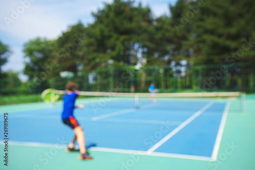 Teenager boy playing tennis on court. Sport summer concept. Blurred background. © IrynaV