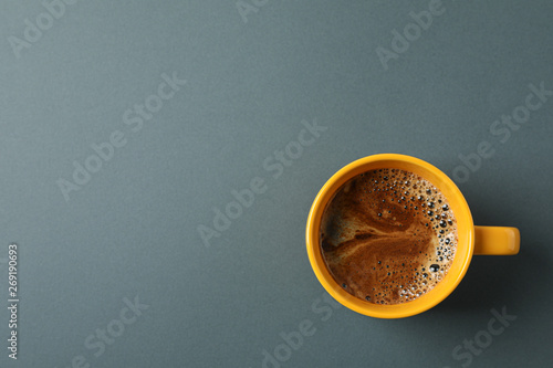 Cup of coffee with frothy foam on black background, space for text and top view. Coffee time accessories